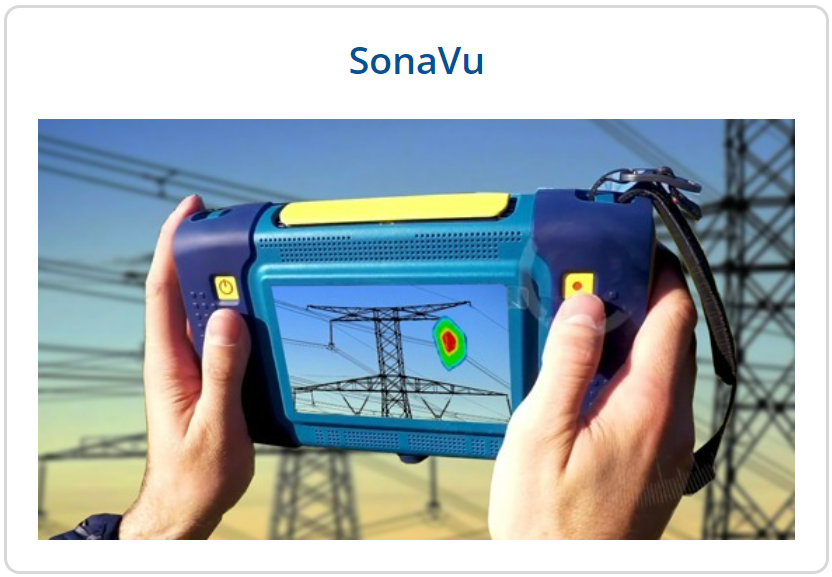 Two hand holding a machine with pylons in the background